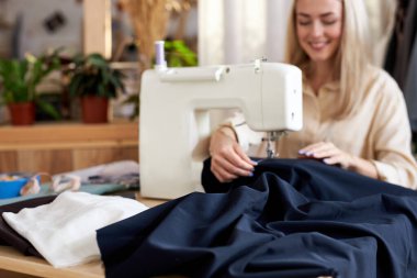 Terzi atölyesinde dikiş makinesi olan güzel beyaz kadın.