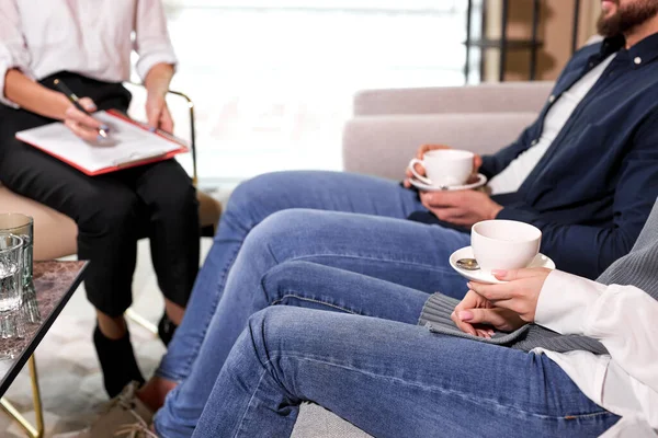 Side view on cropped couple holding cups of coffee at psychologist therapy session — Stock Photo, Image