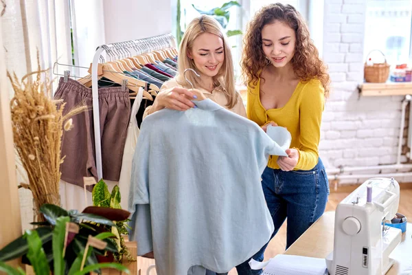 Jovem loira como designer de moda e seu cliente estão falando sobre blusa que precisa ser alterada — Fotografia de Stock