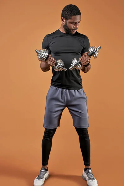 Calce deportivo jóvenes machos levantando pesas, mancuernas —  Fotos de Stock