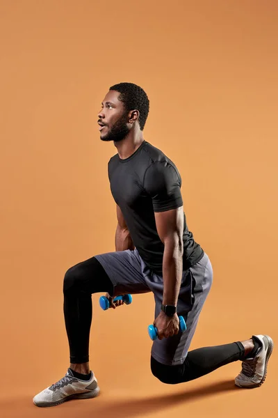 Homem atlético preto em desgaste esportivo fazer exercícios com pesos — Fotografia de Stock