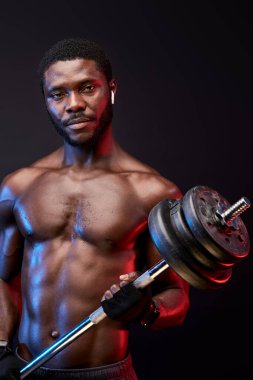Mükemmel kaslı vücutlu ciddi bir vücut geliştirici. Siyah üzerine izole edilmiş poz veriyor.