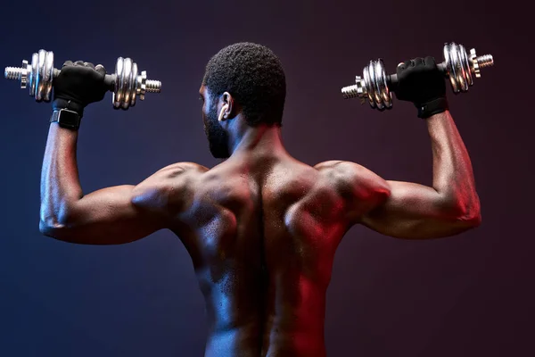 Visão traseira no homem construtor de corpo africano com halteres — Fotografia de Stock