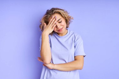 Kafkasyalı bir kadın, izole bir arka planda, endişeli ve yorgun bir ifadeyle bir portre için poz veriyor.