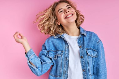 Gülerken saçlarına dokunan iyimser beyaz kadın.