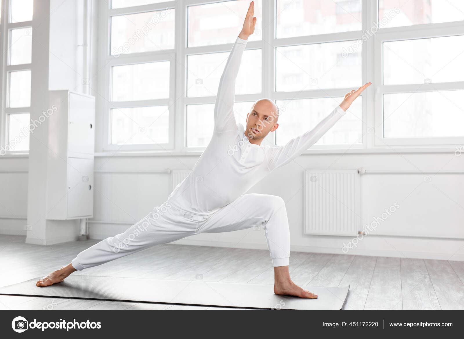 Visão lateral sobre o homem experiente praticando ioga em pé na variação da  postura Guerreiro I ou Virabhadrasana — Foto © romanchazov27 #451172220, image size:1600x1167