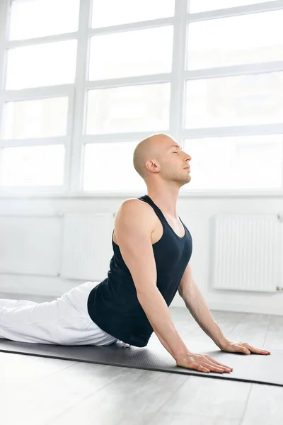 Концентрированный йог мужчина тренируется, упражнения для гибкого позвоночника, urdhva mukha shvanasana, поза собаки вверх — стоковое фото