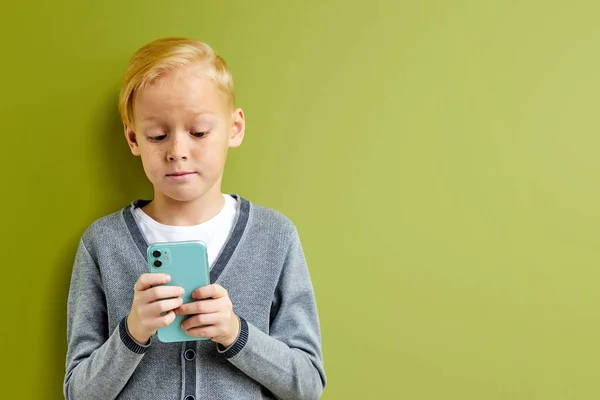 Портрет белокурого белого мальчика с помощью смартфона — стоковое фото
