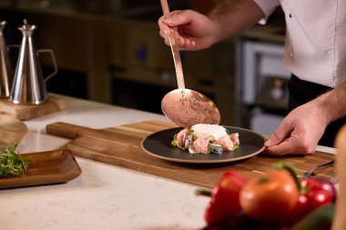 Kırpılmış aşçı salataya eksik malzemeler ekliyor