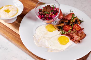 Pastırmalı yumurta, domates ve salata. Tahta tahtada, kafe masasında servis ediliyor.