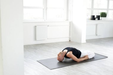 Yoga dersinden önce vücudunu esneten esnek bir Yogi erkeği.