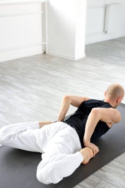 Mandukasana 'da genç bir erkeğin dikiz aynası. Kurbağa pozu.