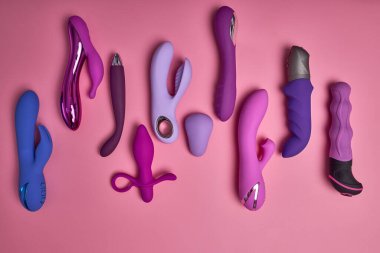 Yoğun orgazm. Pembe arka planda çeşitli g-noktası vibratörleri