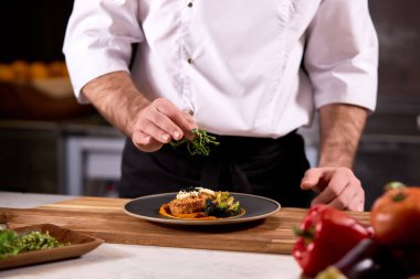 Şef salata ve yeşillik, biraz malzeme ekleyin.