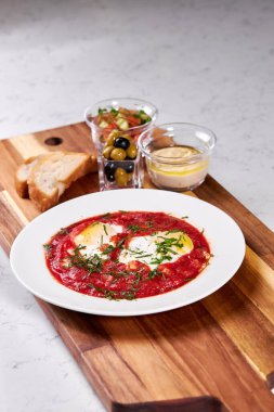 Ekmek, zeytin ve domates soslu yumurta tabağı.