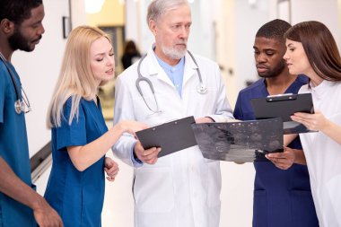 Çok ırklı doktorlar iş sırasında konuşuyorlar, görevleri tartışıyorlar.