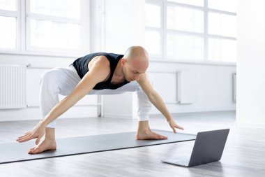 Atletik kaslı genç adam, sumo egzersizleri yapacak, online eğitim gösterecek.