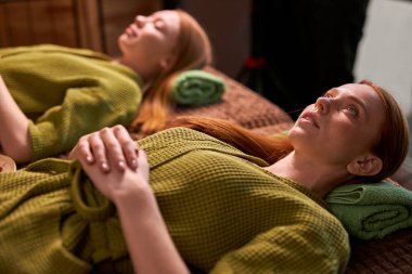 Güzel genç bir kadın kaplıcada yüz ve kafa masajı yaptırmaya hazırlanıyor.