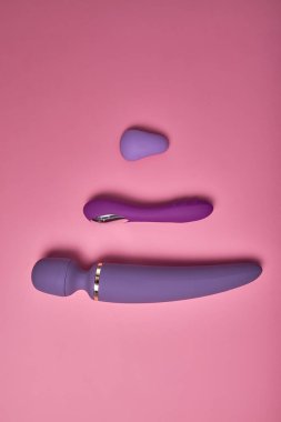 Pembe arka planda üç farklı mor dildo.