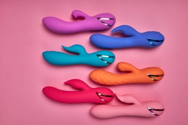 Daha seksi olduğunu keşfet. Pembe arka planda düzenlenmiş farklı renkli G-noktası vibratörleri koleksiyonu