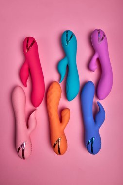 En hassas bölgenizi uyarın. Renkli G-noktası vibratörlerinin bileşimi Pembe Kağıt Arkaplanda Ayarlandı.