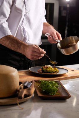 Üniformalı profesyonel aşçı. Yemeklere biraz baharat ekle.