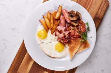 Beyaz Tabakta Kızarmış Yumurta, Sosis, Pastırma, Patates ve Sebze Üzerine Üst Görünüm