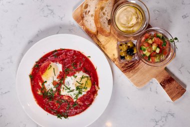 Ekmek, zeytin ve domates soslu yumurta tabağı.