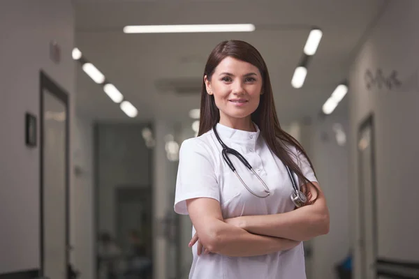 자신감 있는 여성 의사 가 병원 복도에서 카메라로 포즈를 취하는 모습 — 스톡 사진