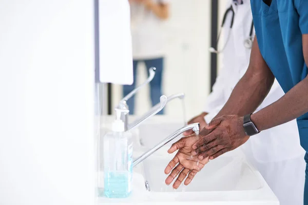 Afro Doctor Man washing hands properly with soap to be protected for Coronavirus 2019-nCoV during work