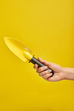 Sarı arkaplanda izole edilmiş küçük bahçe küreği aracı