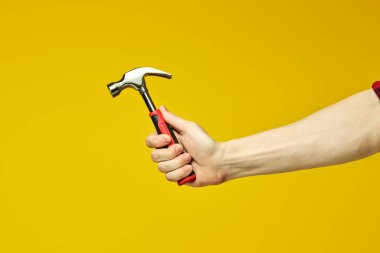 Kırpılmış erkek ellerinde lastik saplı çekiç.