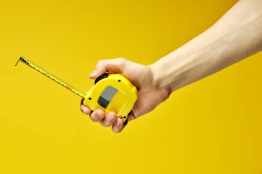 Sarı marangoz, sarı üzerine izole edilmiş imparatorluk ölçeğinde şerit ölçer.