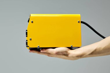 Kaynak makinası, sarı renkler, kırpılmış erkeğin ellerinde.