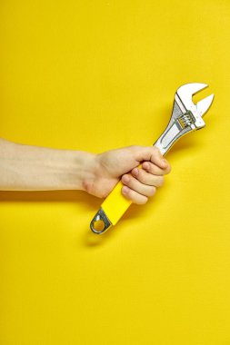 Ayarlanabilir metal anahtar ellerde. Arkaplan pankartı, poster ve daha fazlası için ayarlanabilir metal anahtar.