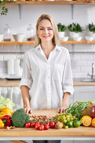 woman food blogger engaged in process of preparing food in kitchen from fresh vegetables