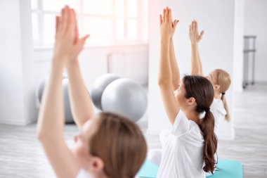Spor salonundaki genç kadınlar için doğum öncesi yoga. Hamile kadınlar yoga yapıyor, meditasyon yapıyor.