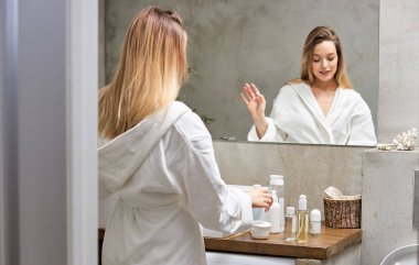 Tuvalette kozmetik kullanan güzel bir kadın.