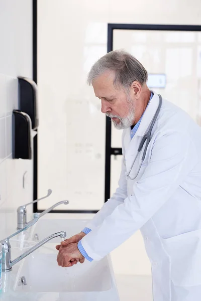 Senior Caucasian Doctor washing Hands Before Operation