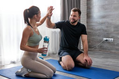 Mutlu çift, evde başarılı bir antrenmandan sonra birbirlerine beşlik çakar.