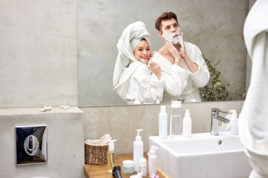 Güzel bir çift eğleniyor, dişlerini fırçalamayı seviyor ve diğer sabah ameliyatlarını banyoda yapıyor.