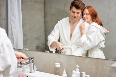 Mutlu genç çift tuvalette el yıkıyor.