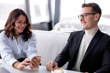 İki iyimser adam ve kadın iş ortağı gülüyor, başarılı bir işbirliğinden sonra iyi vakit geçiriyorlar.