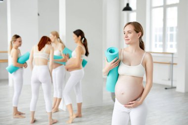 Yogadan önce stüdyosunda spor paspası olan çekici bir anne.