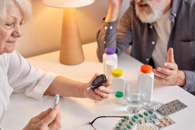 Glukometresi olan son sınıf öğrencisi evde kan şekerini ölçüyor. Diyabet, sağlık konsepti