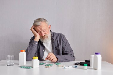 Mutfakta oturan üzgün yaşlı adam Masanın arkasında oturuyor