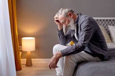 Üzücü bir son sınıf öğrencisi kaygıyla aşağıya bakıyor, üzücü bir şey düşünüyor.