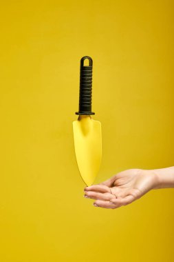 Sarı arkaplanda izole edilmiş küçük bahçe küreği aracı