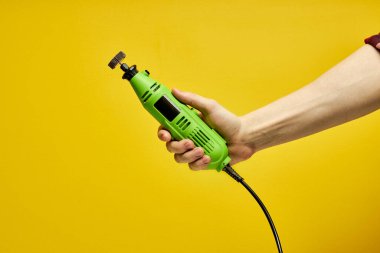 Kopyalama alanı, yakın çekim yeşil boya öğütücüsü kırpılmış erkek ellerinde