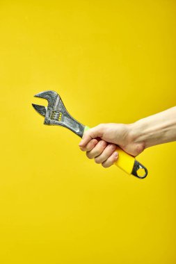 Ayarlanabilir metal anahtar ellerde. Arkaplan pankartı, poster ve daha fazlası için ayarlanabilir metal anahtar.
